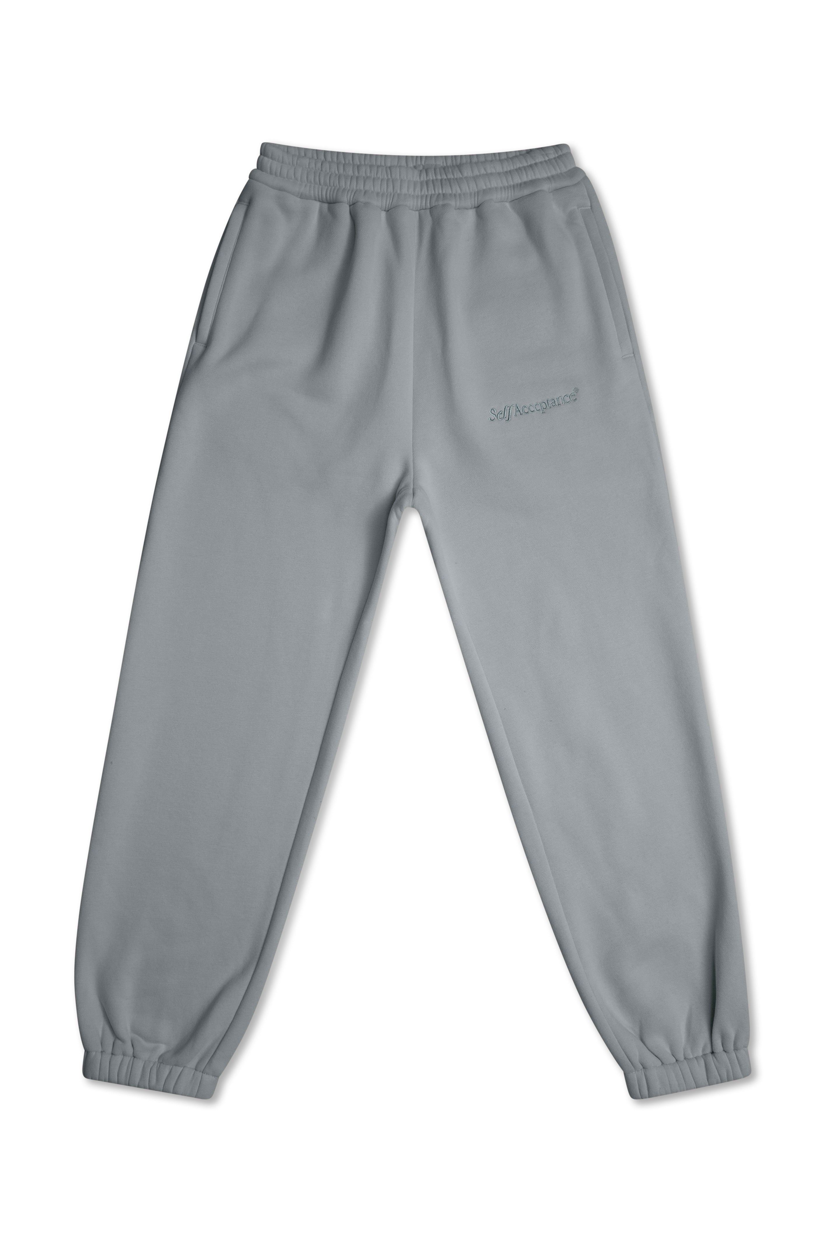 Dusty blue jogger sweatpants with an elastic waistband and cuffed ankles, featuring a small dark gray script logo on the upper left thigh, shown against a plain white background.