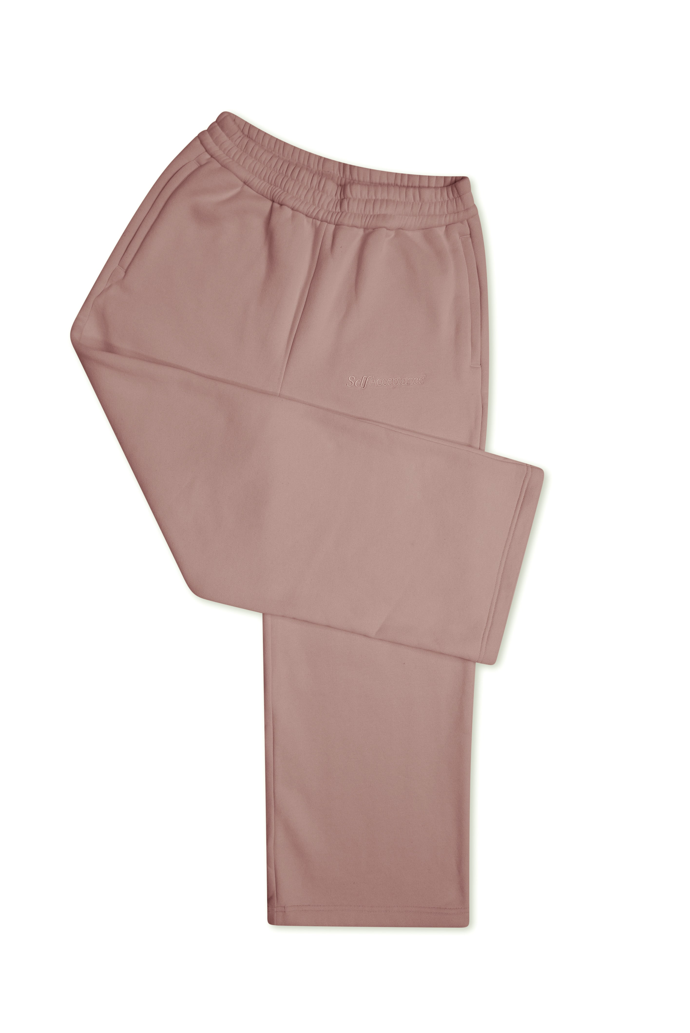 A pair of dusty rose or mauve-colored lounge pants folded neatly on a solid white background.